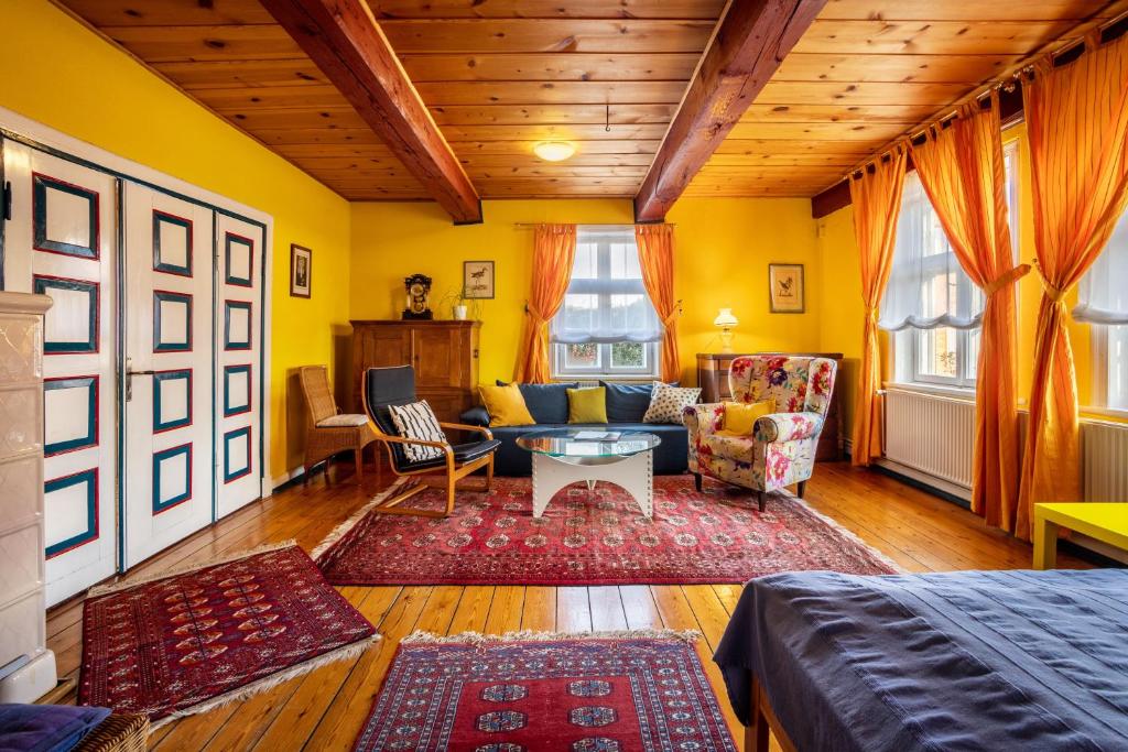 a living room with yellow walls and wooden ceilings at Ferienwohnung Reet op de Eck in Bargenstedt