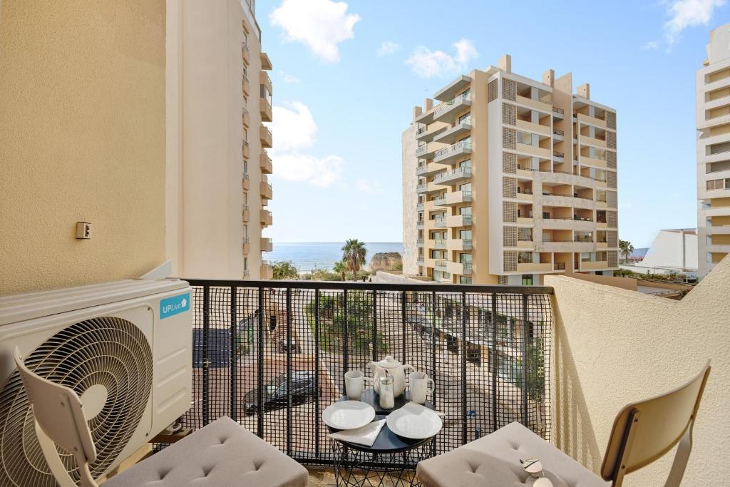 a balcony with chairs and a washer and dryer at Casa Farol in Portimão