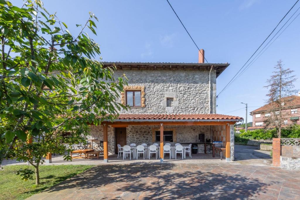 an external view of a stone house with a table and chairs at Casa Trasmiera in Solórzano