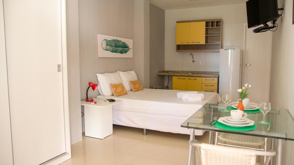 a bedroom with a bed and a table and a kitchen at Pecem Beach Hotel - Aval Hotel in Pecém