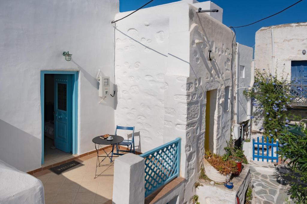 a balcony with blue chairs and a blue door at Karai traditional house in Astypalaia