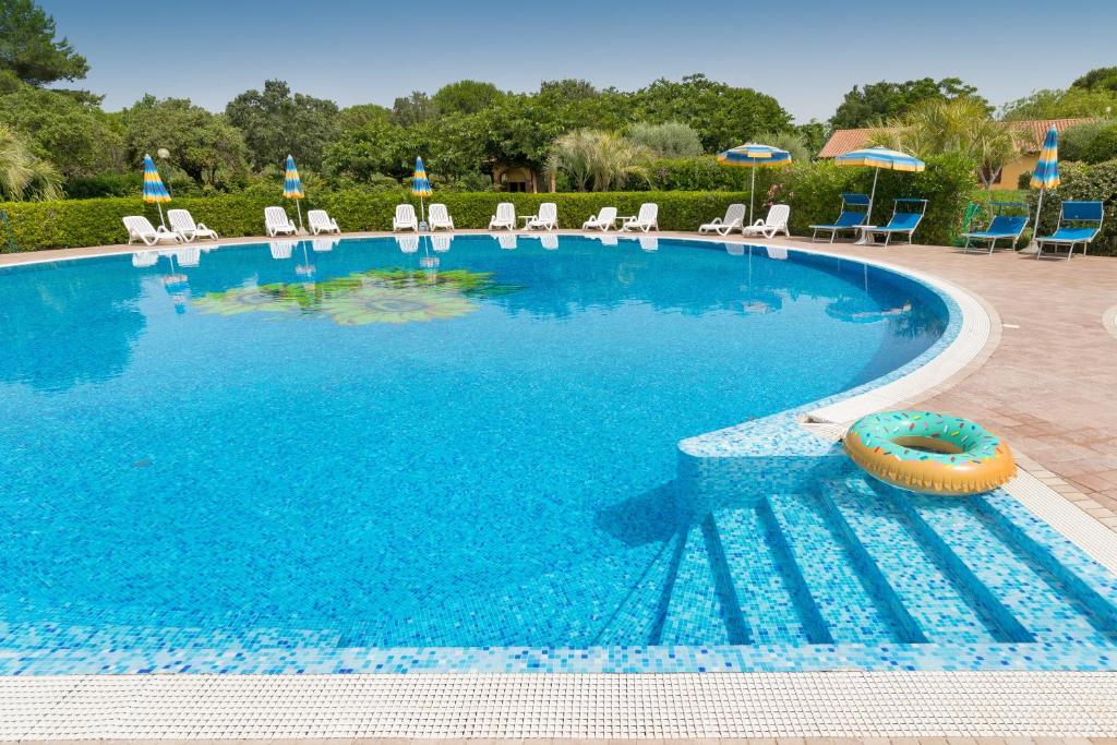 a large swimming pool with chairs and umbrellas at Il Girasole - Limone in Venturina Terme