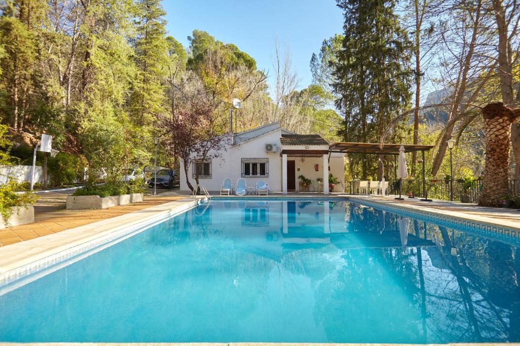 a swimming pool with blue water in front of a house at Casa Arroyo Colmenar in Villanueva del Arzobispo