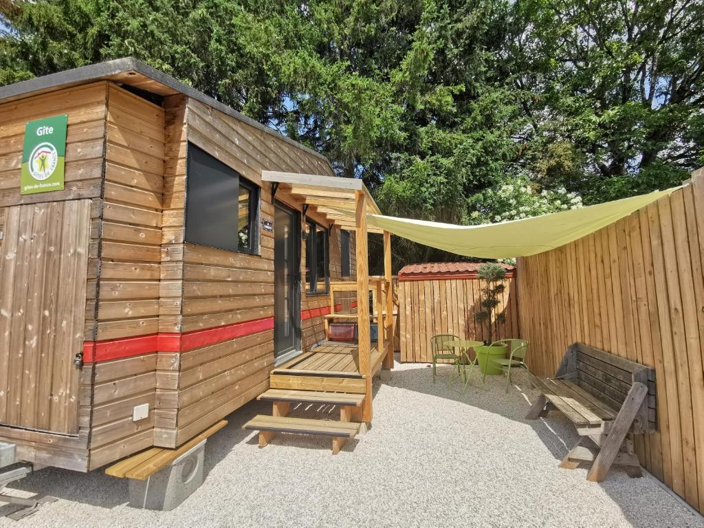 a wooden cabin with a tent and a bench at La Charmotte in Verbiesles