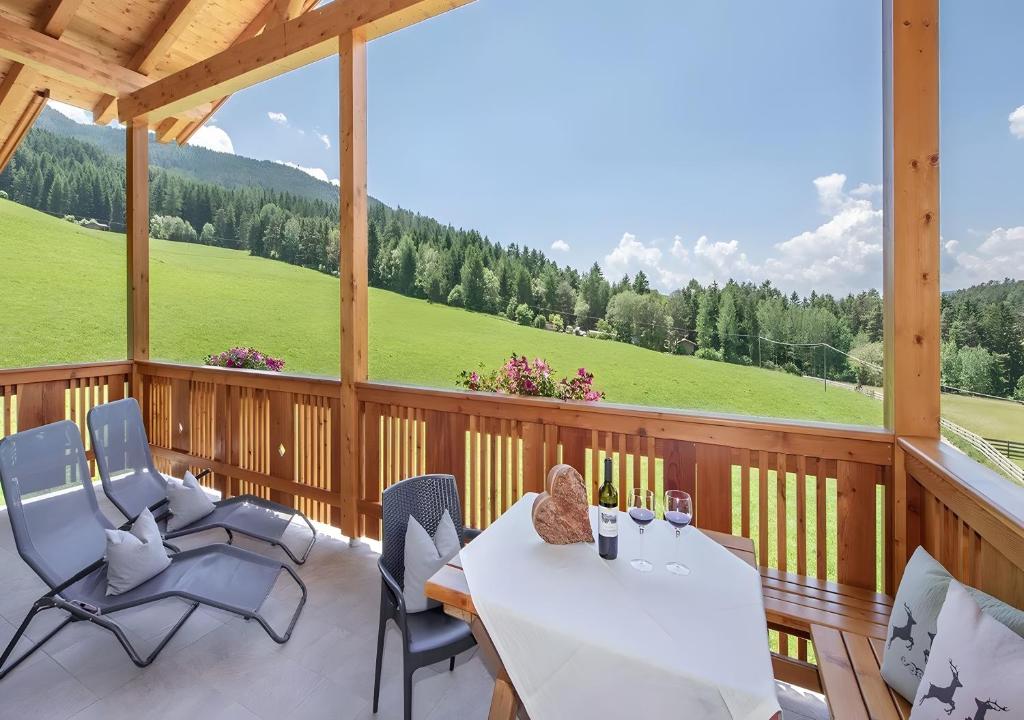 a screened in porch with a table and chairs at Appartments Radauerhof in Castelrotto