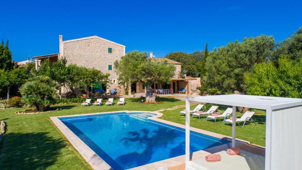 a villa with a swimming pool and a house at Finca Rafal in Son Servera