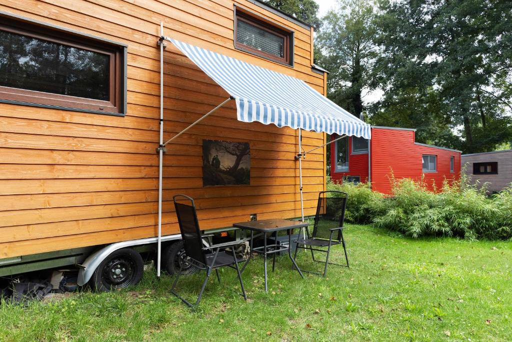 a table and chairs in front of a tiny house at Tiny House Ernesto in Lehnin