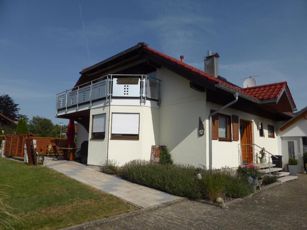 a white house with a balcony on top of it at Haus Bross in Hayingen