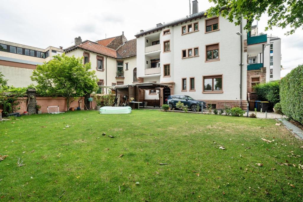 a yard with a large lawn in front of a building at Apartment Albert-Schulte Park in Worms