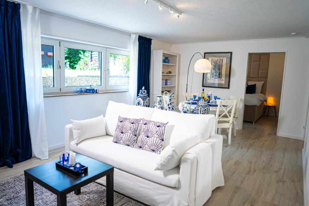 a living room with a white couch and a table at Royal Delft Boutique Apartment in Dinslaken