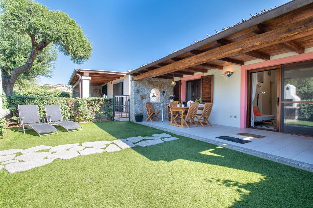 a garden with a patio and a table and chairs at Manessy in Badesi