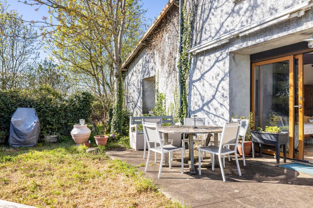 a patio with a table and chairs next to a building at Bourdeverre Chambres D'hôtes in Sanxay