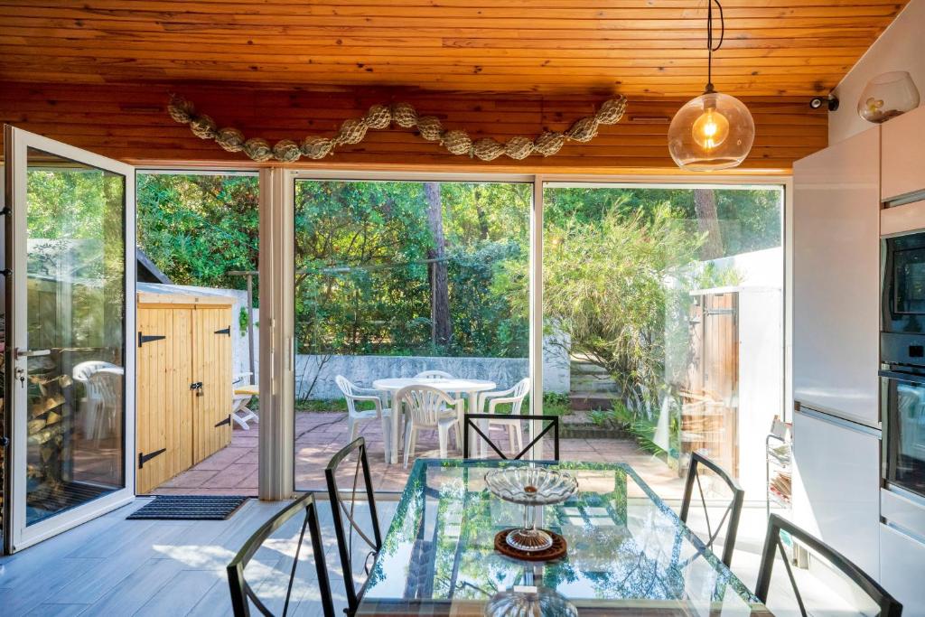 a dining room with a glass table and chairs at Villa Patio Proche Plage in Seignosse