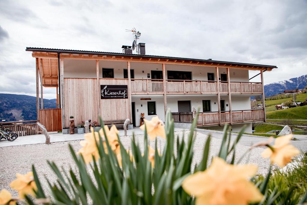 a building with orange flowers in front of it at Kieserhof Apartment Alm in Terento