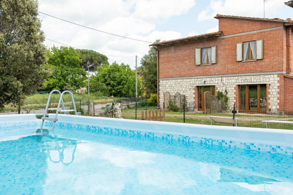 a large swimming pool in front of a house at Cottage Casa Luisa in Montalcino
