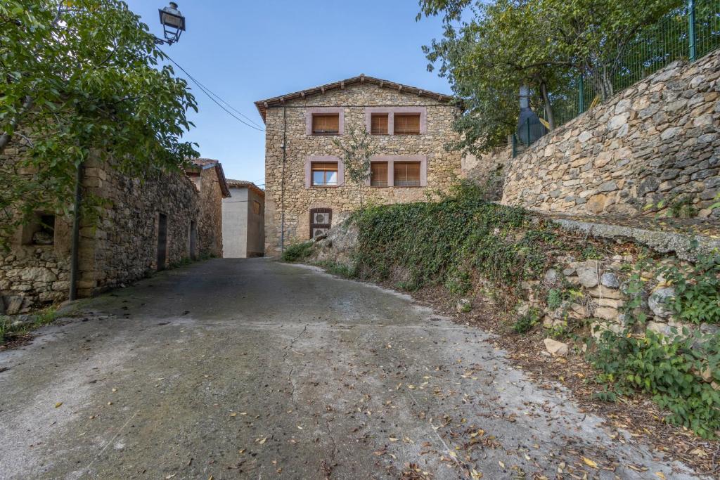 an empty road in front of a stone building at Jaumet 2 Sant Martí de Barcedana in Aransís