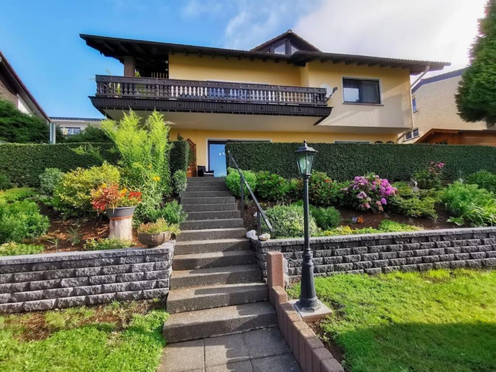 a house with a staircase in front of a yard at Zur schönen Aussicht in Schotten
