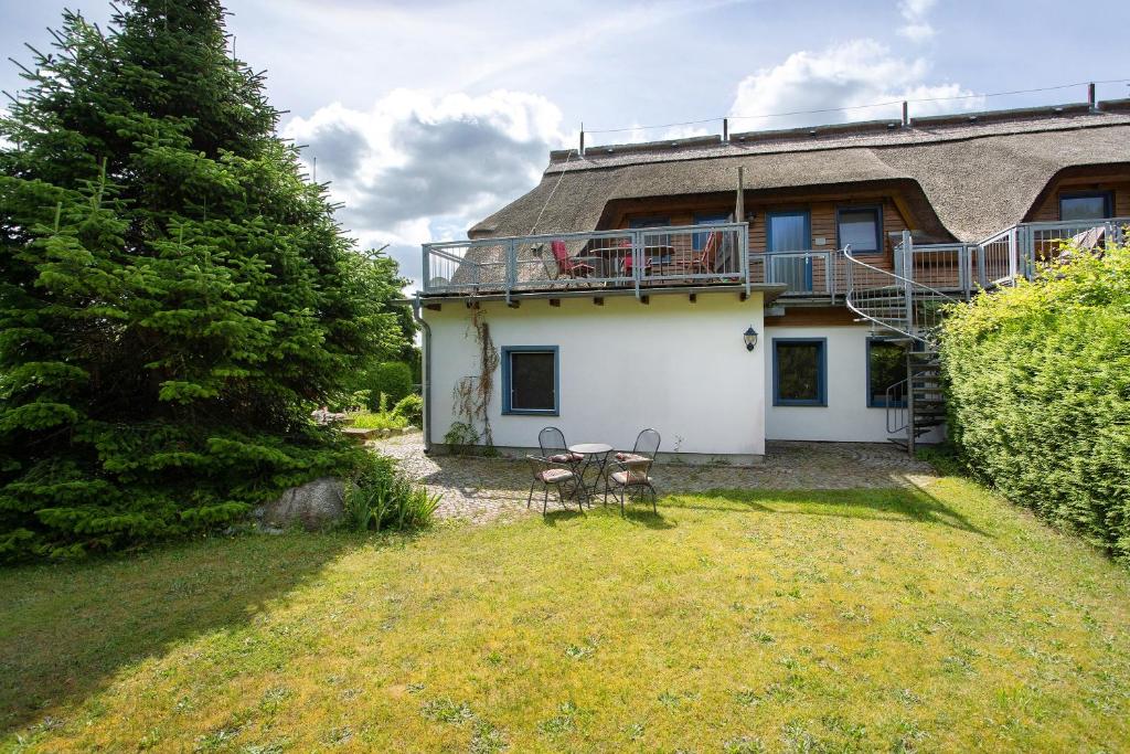 a house with a thatch roof and a patio at Landhaus Peenemünde - Garten in Peenemünde