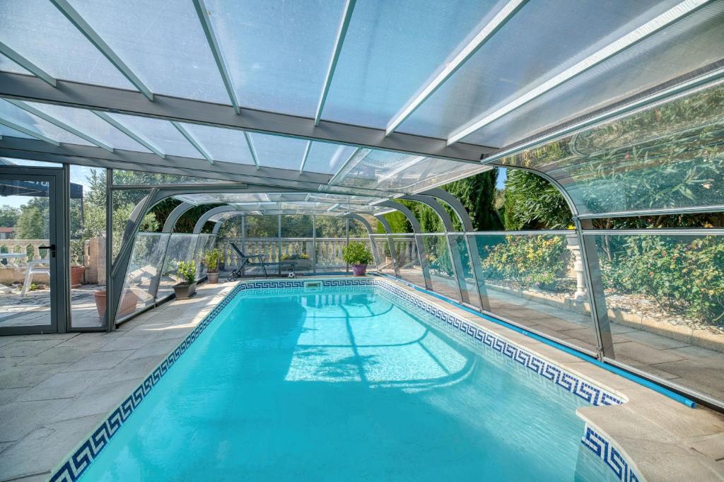 an indoor swimming pool with a glass ceiling at Chez Anne Marie Et Daniel in Gardouch