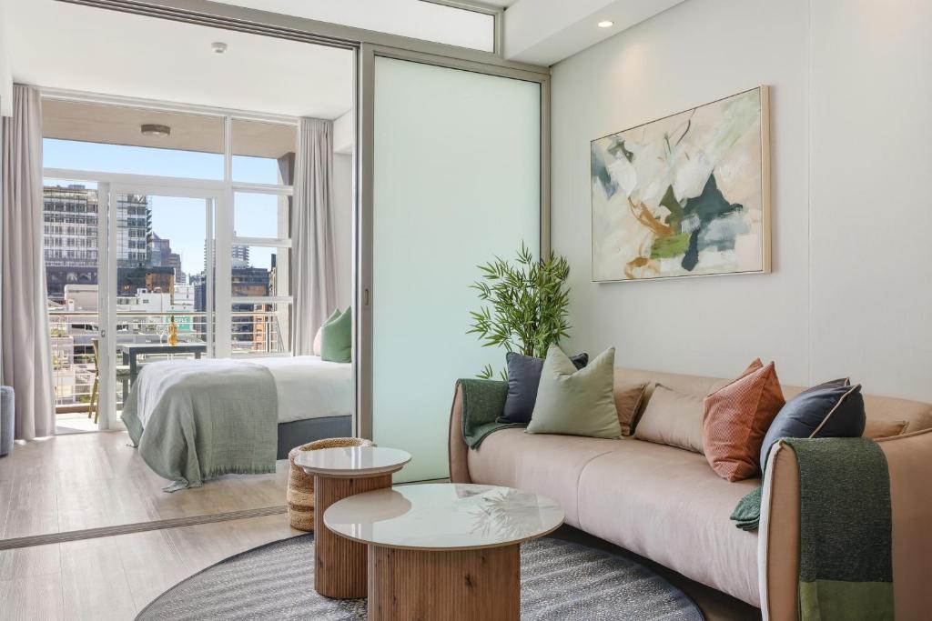 a living room with a couch and a table at Backup-Powered Trendy City Balcony Apartment in Cape Town