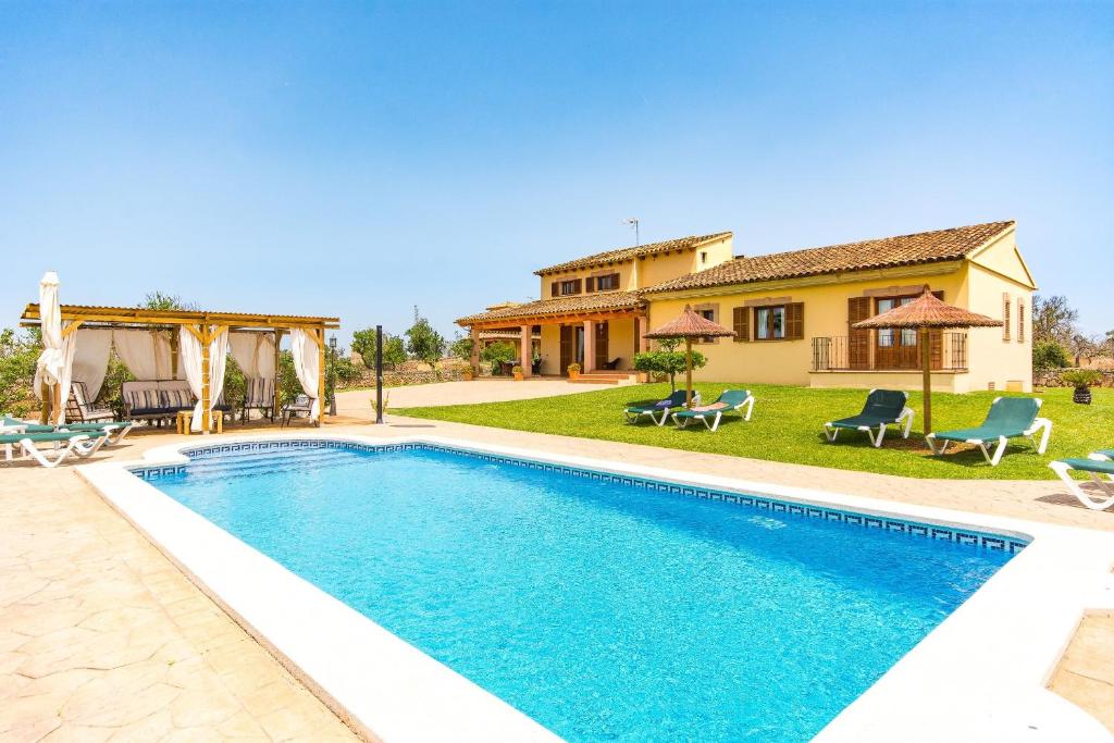 a villa with a swimming pool and a house at Finca Can Cocou in Can Picafort