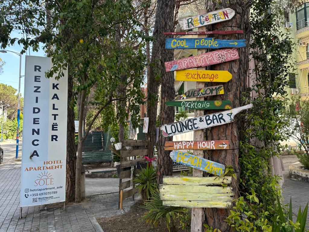 a pole full of signs on a street at Rezidenca Kalter Durres in Golem