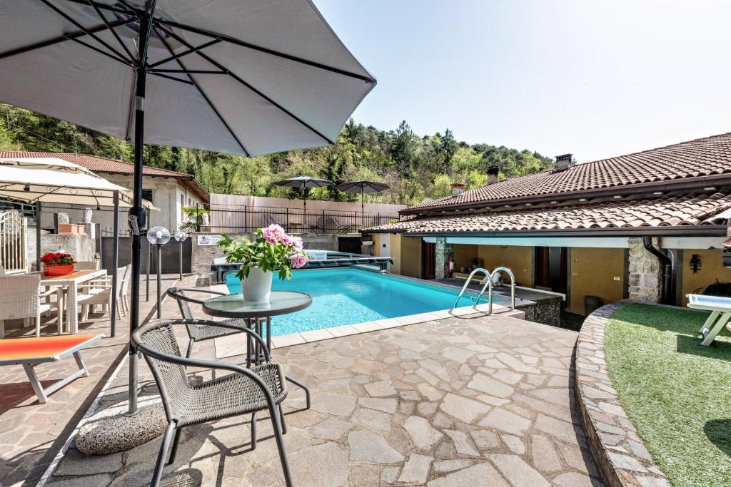 a patio with a table and an umbrella next to a pool at Residence Tatiana A1 in Tremosine Sul Garda