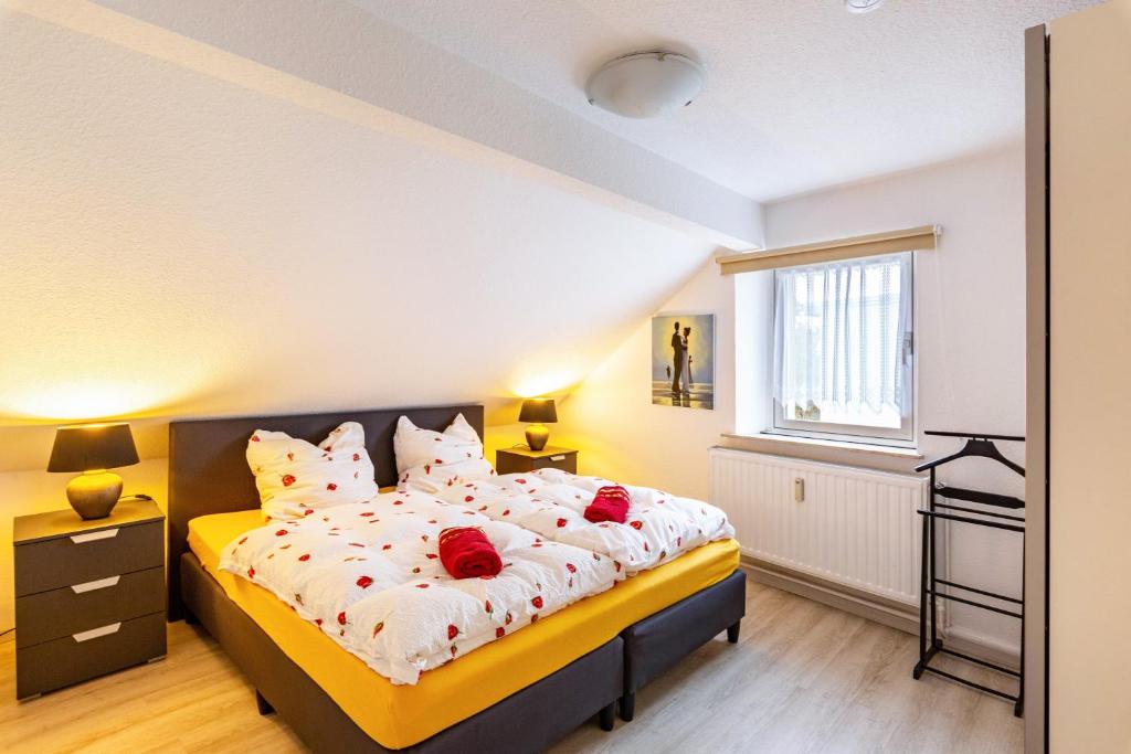 a bedroom with a bed with red roses on it at Tapas Restaurante 2 in Viersen