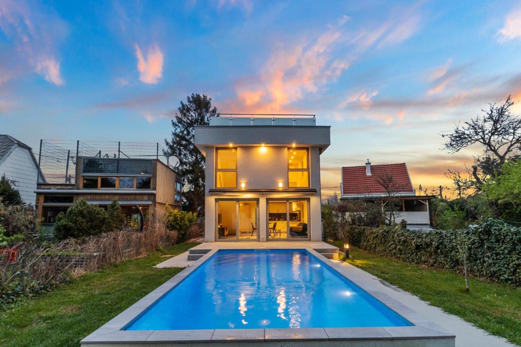 a home with a swimming pool in front of a house at Villa Jäger mit Pool in Wien in Vienna