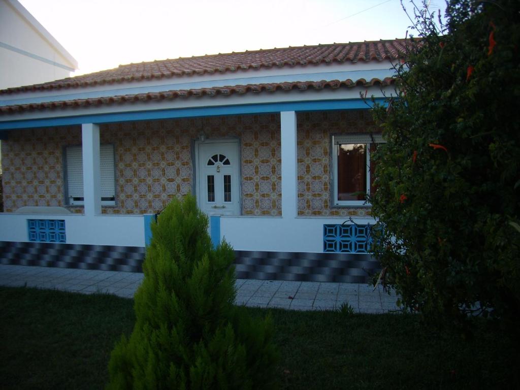 una pequeña casa con una puerta blanca y una ventana en Casa da Amoreira, en Luz de Tavira