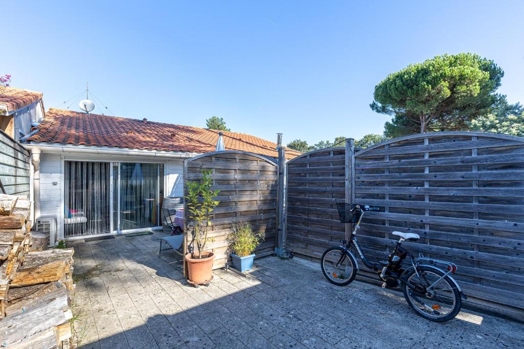 a bike parked next to a fence next to a house at Studio Cosy Climatisé, Cap Bretron in Capbreton