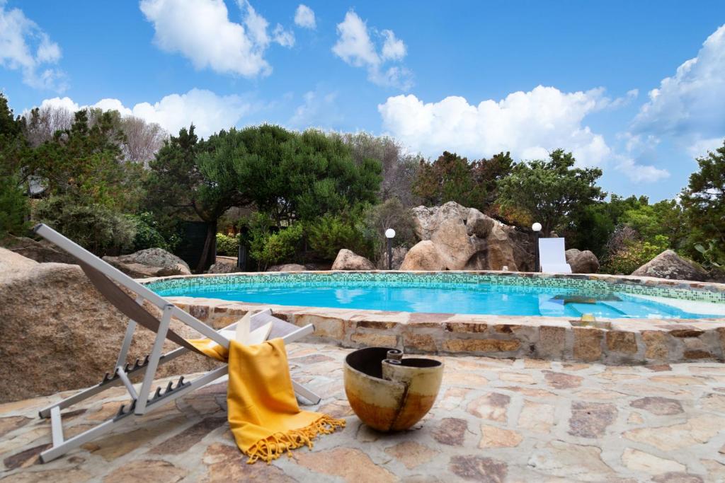 a swimming pool with a lounge chair and a bucket at Nido in Monte Petrosu