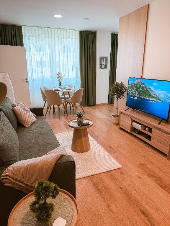 a living room with a couch and a flat screen tv at Bloom Olive Apartment in Trenčín