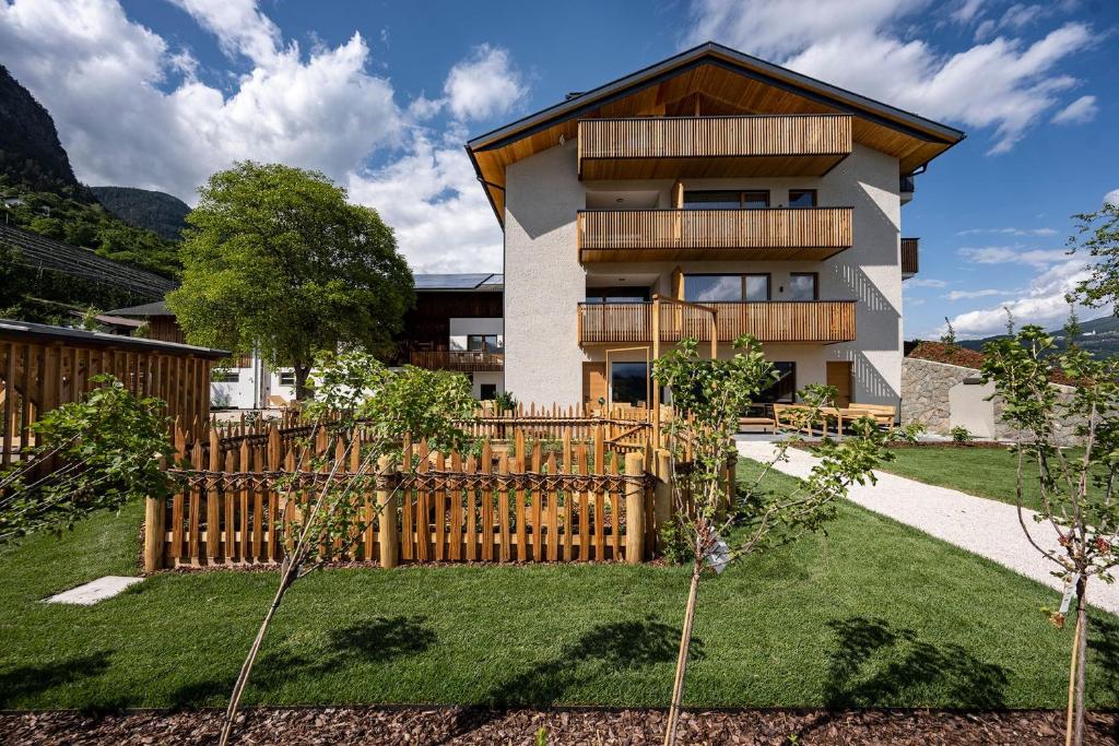 a house with a wooden fence in a yard at Oberfallerhof Apartment Inni in Barbiano