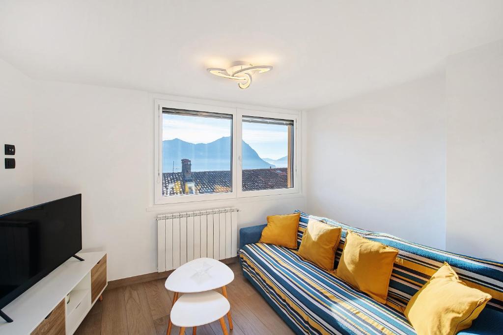 a living room with a couch and a tv at Cà De Qualì in Costa Volpino