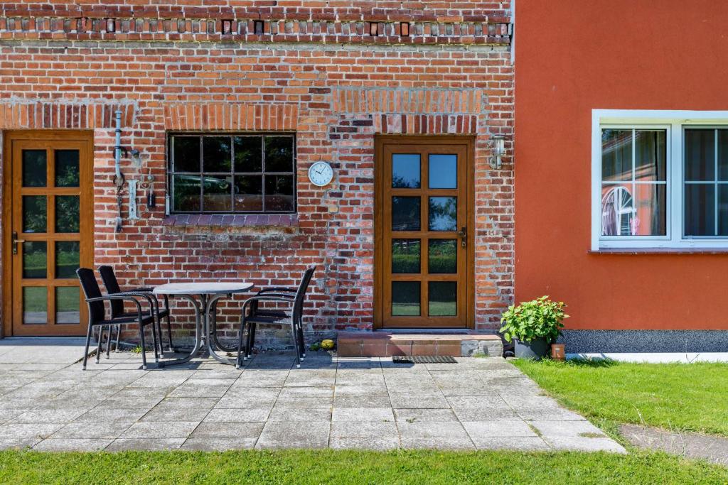 a table and chairs in front of a brick building at Kranichnest in Lüdershagen