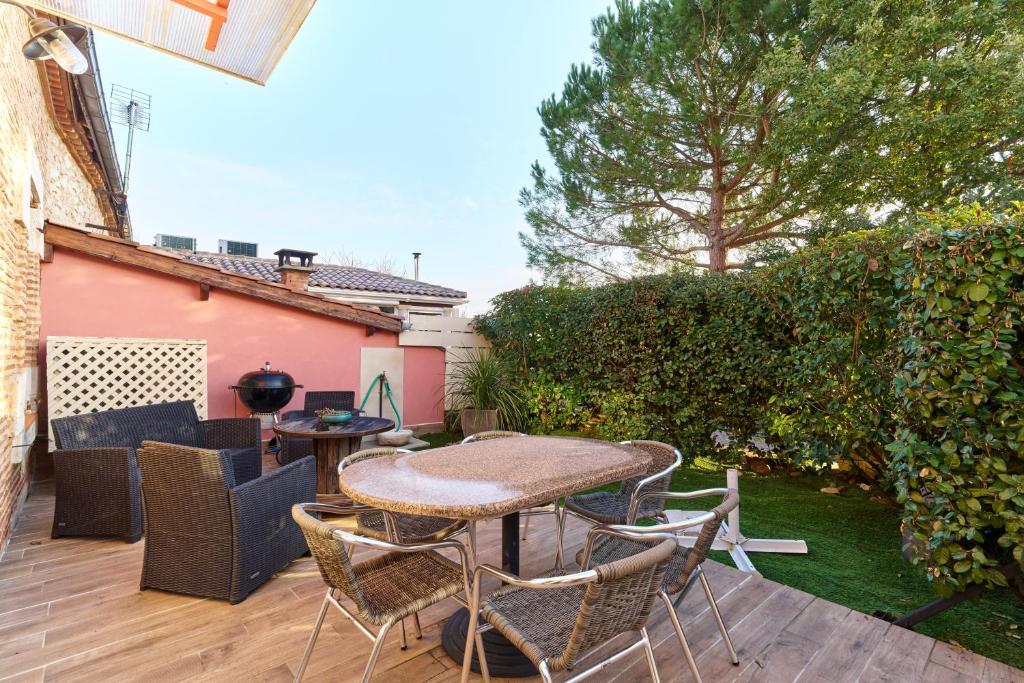 a patio with a table and chairs on a deck at Logement Pascal in Villeneuve-sur-Lot