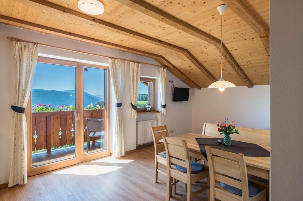 a dining room with a table and a large window at Mongaduierhof Apt Schlern in Fie allo Sciliar