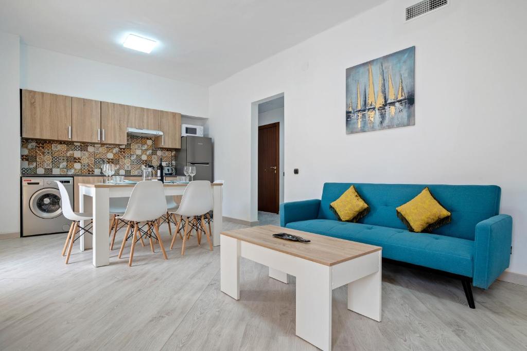 a living room with a blue couch and a table at Cambrils Turistic 3a in Cambrils
