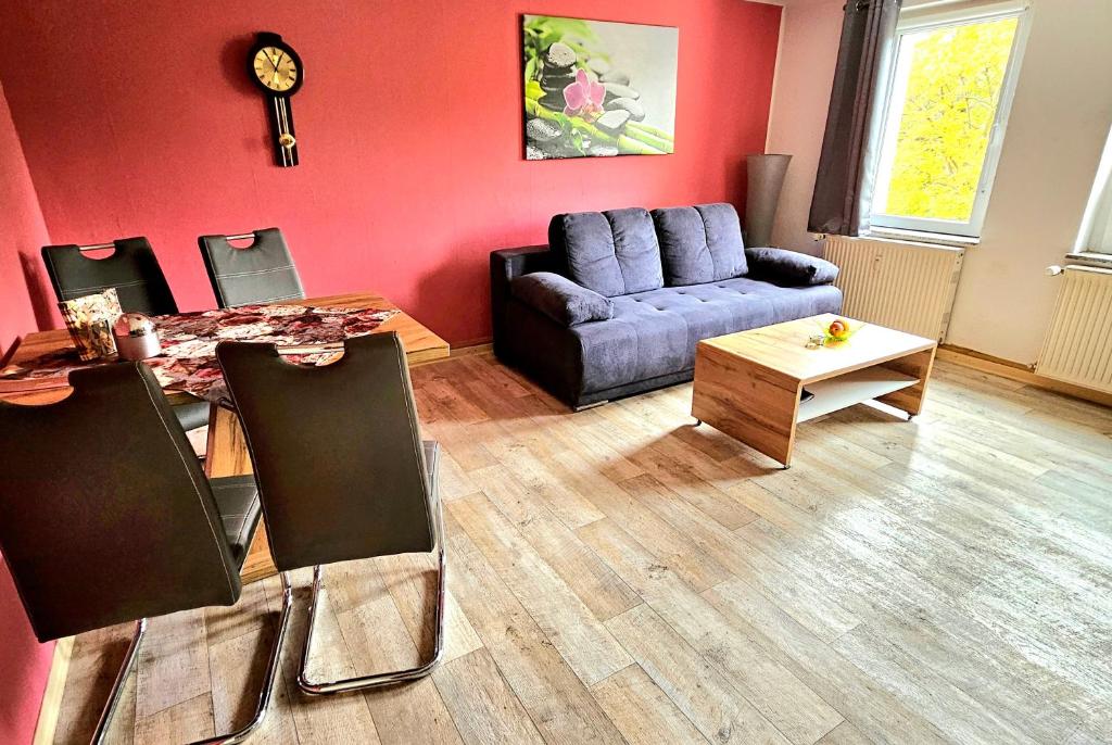 a living room with a blue couch and a table at Ferienwohnung Blumen in Radeberg
