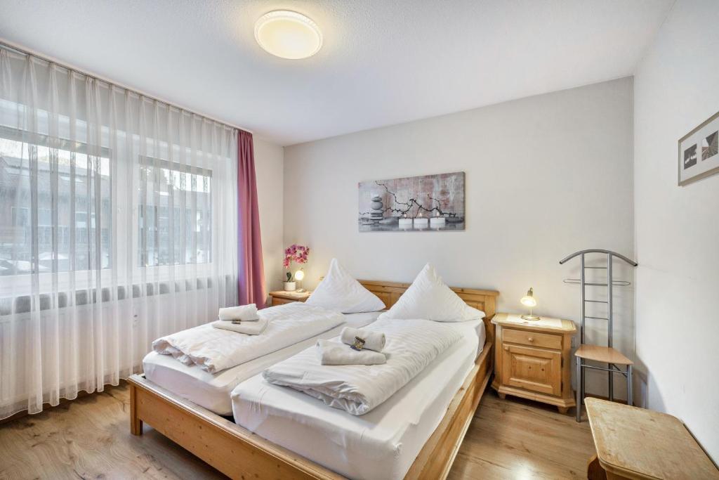 a bedroom with two beds and a large window at Fewo mit Bergblick, Pool, Sauna in Oberaudorf