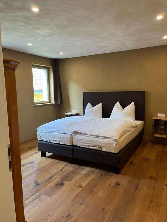 a bedroom with a large bed with white sheets and pillows at Bio Bausewein - No.2 Apartment in Iphofen