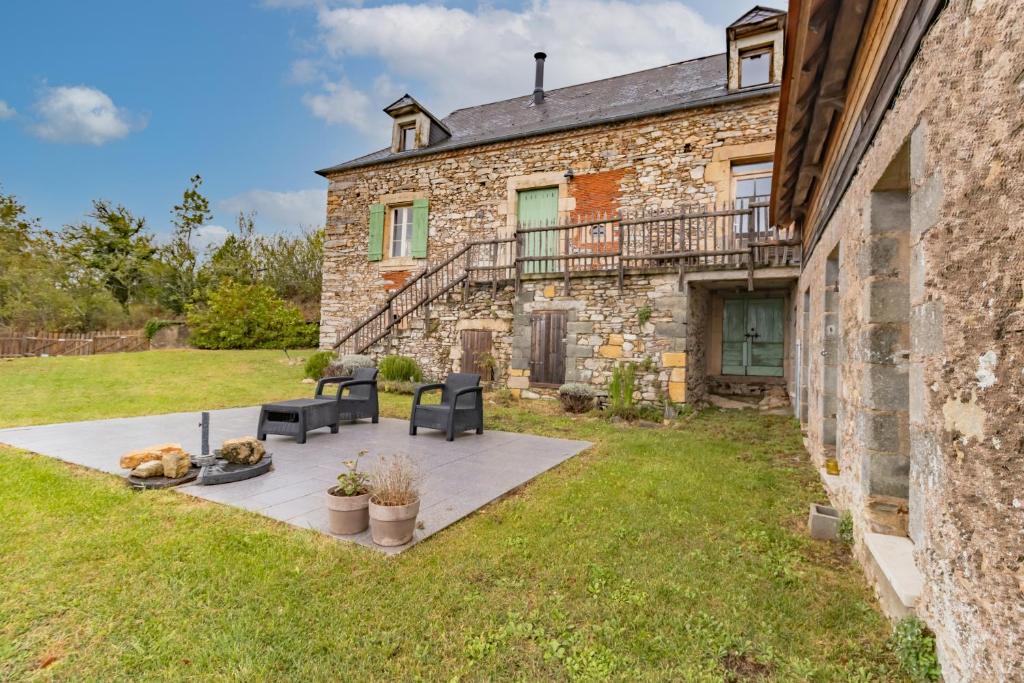 a stone house with a patio in the yard at La Dordogne en Périgord in Salagnac