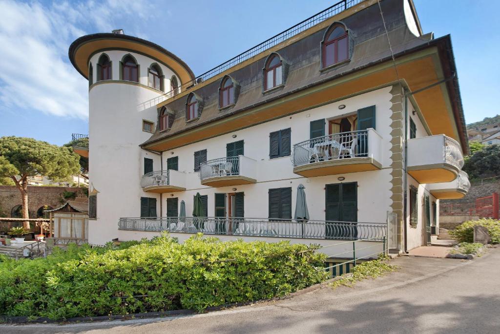 a large white building with a tower on top of it at Appartamento Monolocale Moneglia 25 in Moneglia