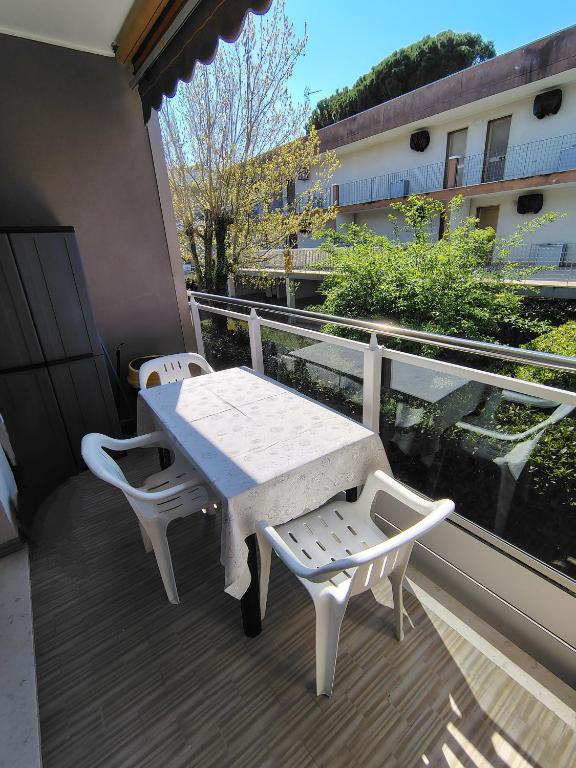 a white table and two chairs on a balcony at "Le Betulle 10" cinque minuti dal mare, Self check in in Bibione