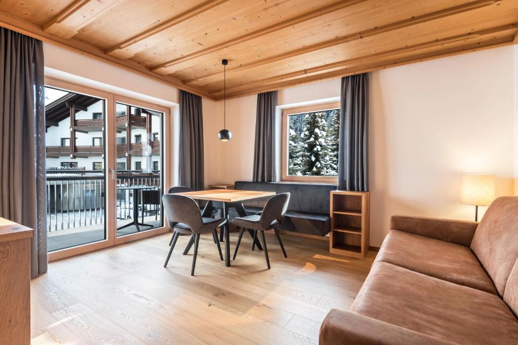 a living room with a table and chairs and a couch at La Grambla App Sella 1 in Santa Cristina Gherdëina