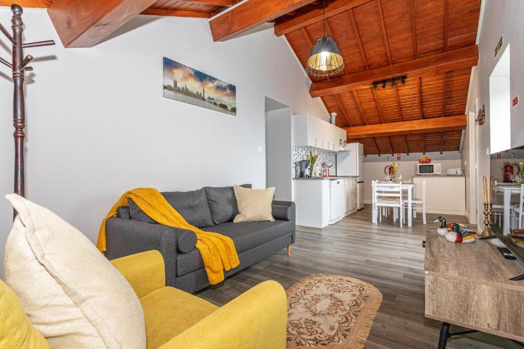a living room with a couch and a kitchen at Oásis Fonte Grande in Santo António