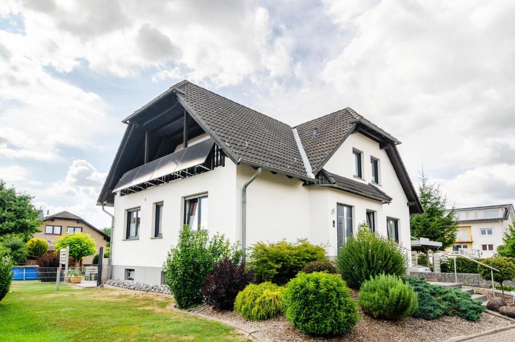 a white house with a black roof at Ferienwohnung an der Ohme in Warburg