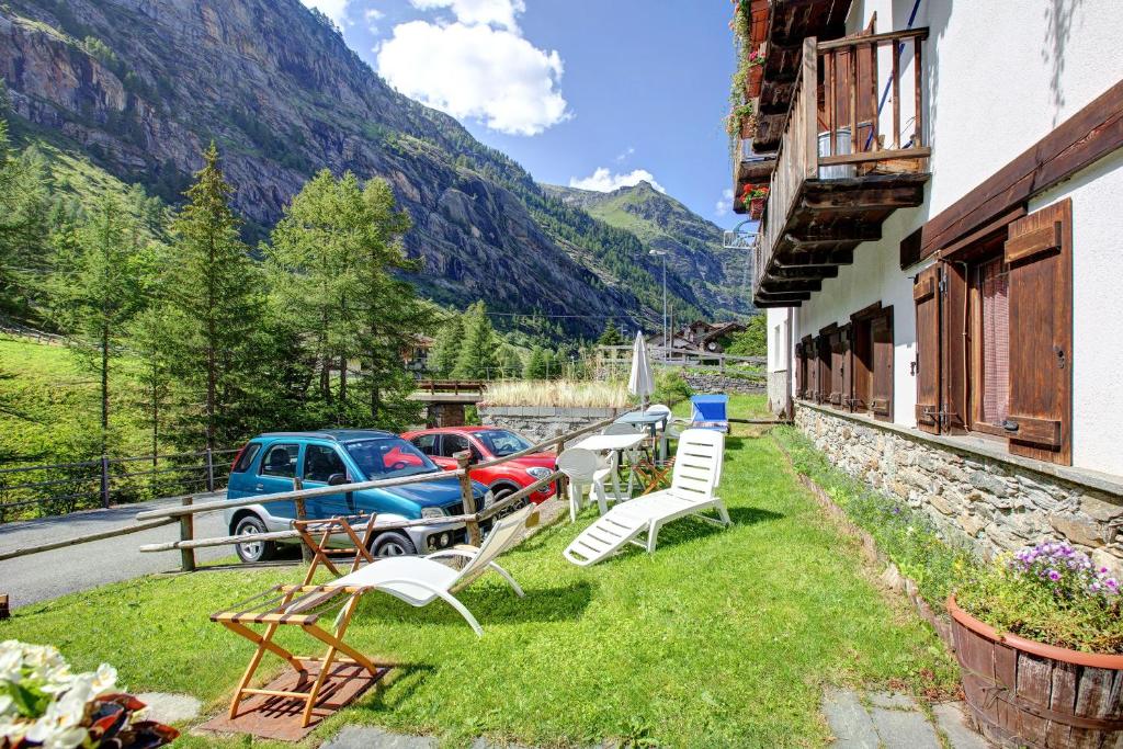 a patio with chairs and a car parked next to a building at Lo Peiglo Valgrisenche in Valgrisenche