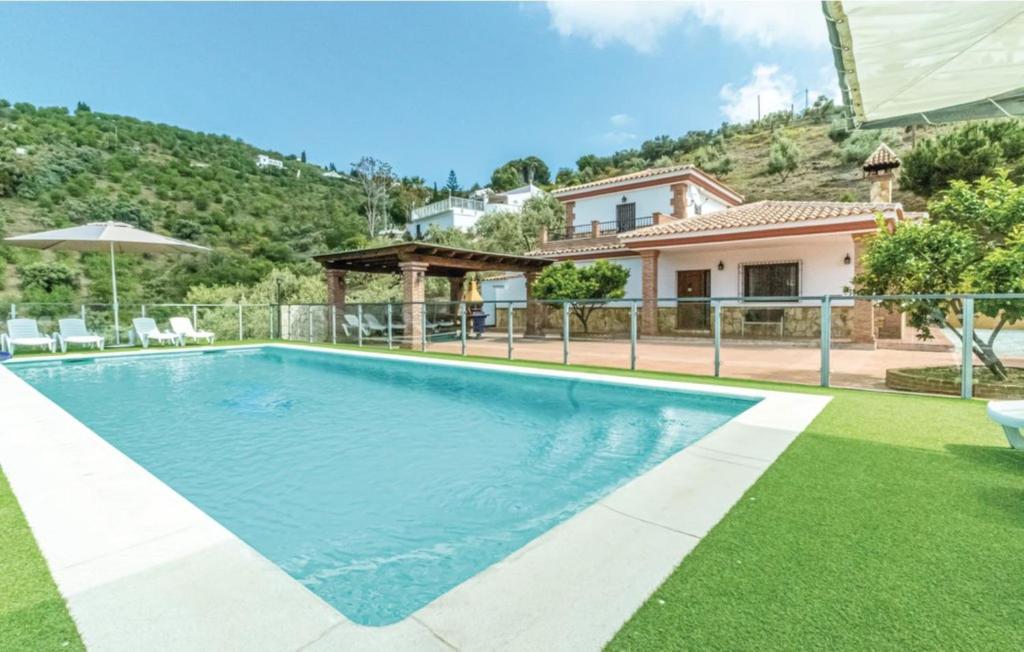 a swimming pool in front of a house at Casa Olivia in Cómpeta
